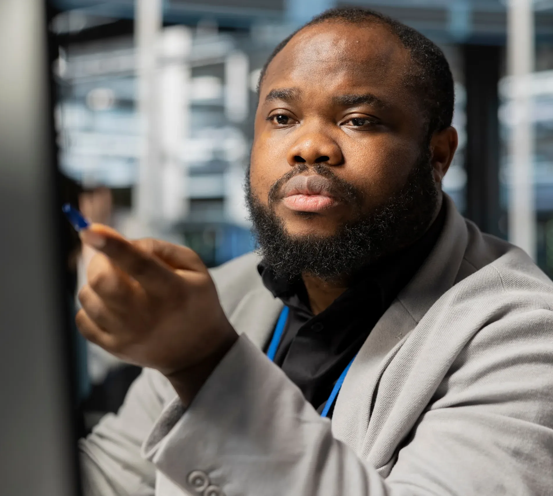 A professional man in a business setting points at a screen while analyzing information, showing focused review and decision making supported by data driven processes at Alimentiv